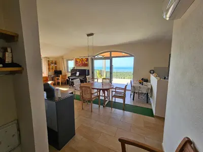 a kitchen and living room with a table and chairs at Cadre exceptionnel Calme , Nature, Confort in Glavatičići