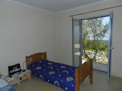a bedroom with a bed and a sliding glass door at Cadre exceptionnel Calme , Nature, Confort in Glavatičići