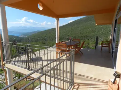 a balcony of a house with a table and chairs at Cadre exceptionnel Calme , Nature, Confort in Glavatičići