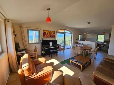 a living room with a couch and a dining room at Cadre exceptionnel Calme , Nature, Confort in Glavatičići