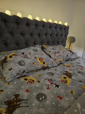 a bed with a comforter with santa clauses and christmas at Apartman AURORA CETINJE in Cetinje