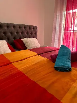 a colorful bed with two pillows on top of it at Apartman AURORA CETINJE in Cetinje