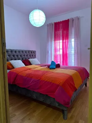 a bedroom with a large bed with a colorful blanket at Apartman AURORA CETINJE in Cetinje