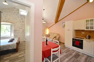 a kitchen and a living room with a table in a room at Old Town View - Sunny, Bright & Quiet in Kotor