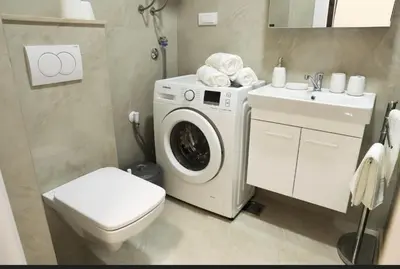 a bathroom with a washing machine and a sink at Studio apartment, 5 minutes to the beach in Bar