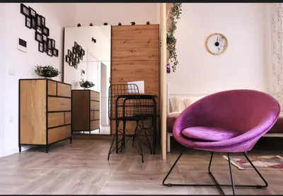 a living room with a purple chair and a mirror at Studio apartment, 5 minutes to the beach in Bar