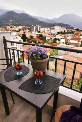 a table with flowers on top of a balcony at Studio apartment, 5 minutes to the beach in Bar