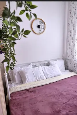 a clock on a wall above a bed with pillows at Studio apartment, 5 minutes to the beach in Bar