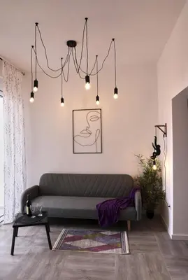 a living room with a couch and a chandelier at Studio apartment, 5 minutes to the beach in Bar