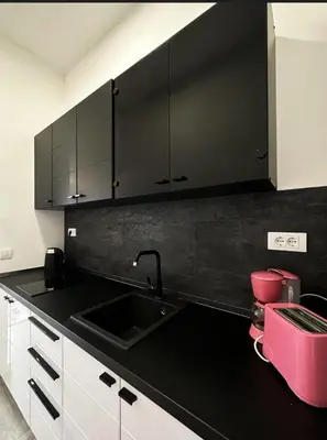 a kitchen with a sink and a black counter top at Studio apartment, 5 minutes to the beach in Bar