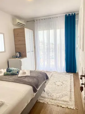 a bedroom with a bed and a large window at NOA Guest House in Ulcinj