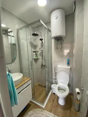 a bathroom with a shower and a toilet and a sink at NOA Guest House in Ulcinj