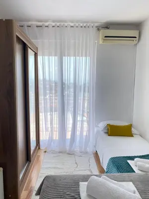 a bedroom with two beds and a large window at NOA Guest House in Ulcinj