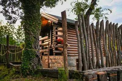 a wooden house with a fence and a flower box at Via river in Podgorica