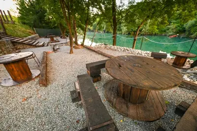 a wooden table and benches in a park at Via river in Podgorica