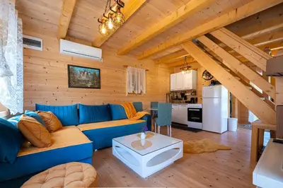 a living room with a blue couch and a kitchen at Holiday Home MIA in Rijeka Crnojevića