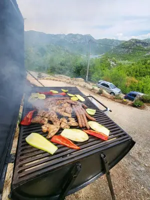 a grill with some meat and vegetables on it at Holiday Home MIA in Rijeka Crnojevića