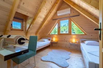 a room with two beds and a desk in a cabin at Holiday Home MIA in Rijeka Crnojevića