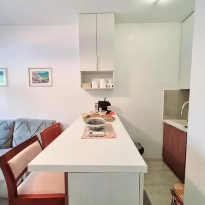 a kitchen with a white island in a room at Apartman Podgorica in Podgorica
