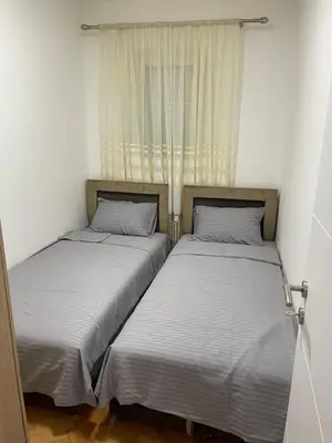 two twin beds in a room with a window at Apartment Božović in Budva