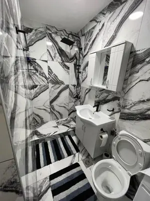 a bathroom with a black and white marble wall at Apartment Božović in Budva