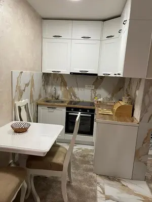 a kitchen with white cabinets and a white table at Apartment Božović in Budva