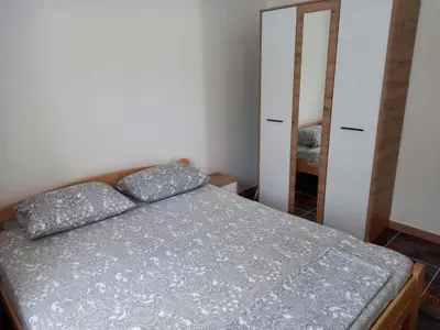 a small bedroom with a bed and a mirror at KIWI in Bar