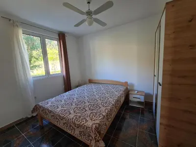 a bedroom with a bed and a ceiling fan at KIWI in Bar