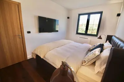 a bedroom with a bed and a flat screen tv at Home Filip in Golubovci