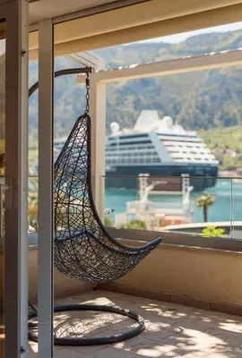a hammock in a room with a cruise ship at Ocea Studio Apartments in Kotor