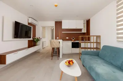 a living room with a blue couch and a table at Ocea Studio Apartments in Kotor