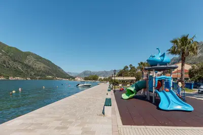 a playground next to a body of water at Ocea Studio Apartments in Kotor