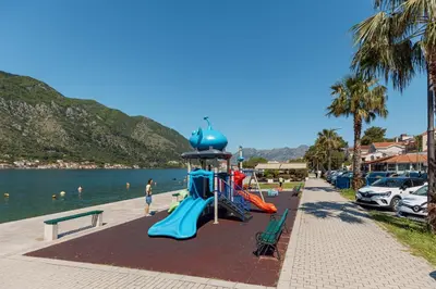 a playground next to the water with a slide at Ocea Studio Apartments in Kotor