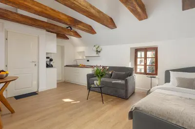 a bedroom with a bed and a couch and a kitchen at Old Town South Gate Apartment in Kotor