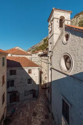 an alley between two buildings with a hill in the background at Old Town South Gate Apartment in Kotor