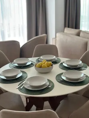 a white table with plates and bowls of fruit on it at Sunny&calmhouse in Bar