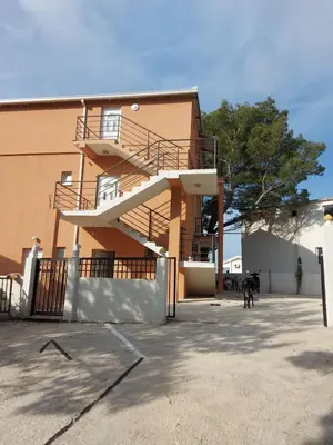 a staircase on the side of a building with a dog at Crni Bor Sutomore in Sutomore
