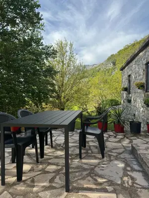 a picnic table and chairs on a stone patio at Nature Escape Montenegro in Kotor