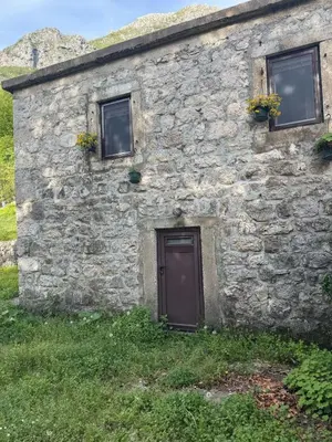 an old stone building with two windows and a door at Nature Escape Montenegro in Kotor