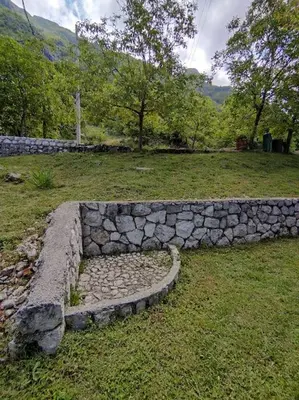 a stone wall in a field next to a field at Nature Escape Montenegro in Kotor