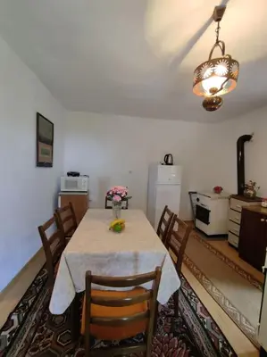 a dining room with a table with chairs and a refrigerator at Nature Escape Montenegro in Kotor