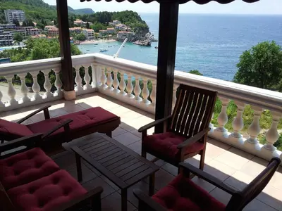 a balcony with chairs and a view of the ocean at Villa Sara Guesthouse in Sveti Stefan