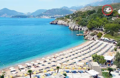 a beach with a bunch of umbrellas and the ocean at Villa Sara Guesthouse in Sveti Stefan