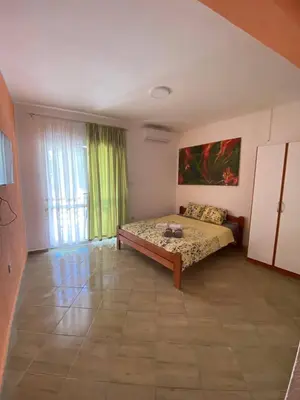 a bedroom with a bed and a painting on the wall at Violit Apartments&Restaurant in Sutomore