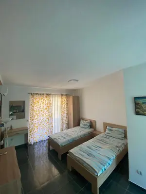 a hotel room with two beds and a window at Violit Apartments&Restaurant in Sutomore