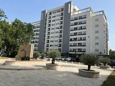 a large building with trees in front of it at Apartment with Seaview Zetagradnja in Bar