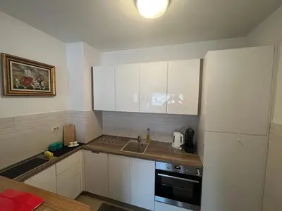 a kitchen with white cabinets and a sink and a refrigerator at Apartment with Seaview Zetagradnja in Bar