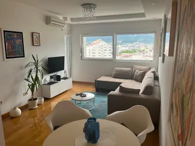 a living room with a couch and a table and chairs at Apartment with Seaview Zetagradnja in Bar