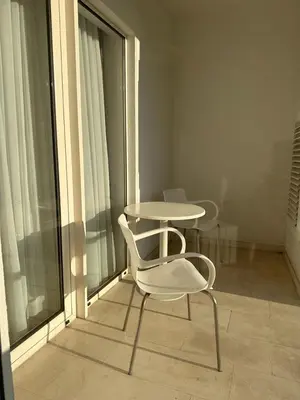 a white chair and a table on a balcony at TC BiG APARTMENTS in Budva