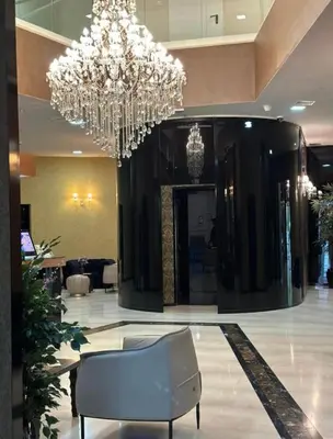 a large lobby with a chandelier and a chair at TC BiG APARTMENTS in Budva